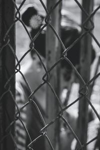 Woman seen through chainlink fence