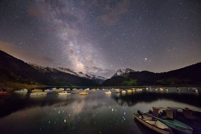 Scenic view of lake and mountains against sky at night