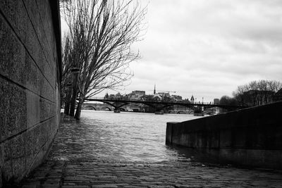 Bridge over river amidst buildings against sky