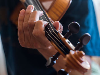 Midsection of man playing guitar