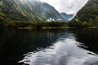 Scenic view of lake by mountains against sky