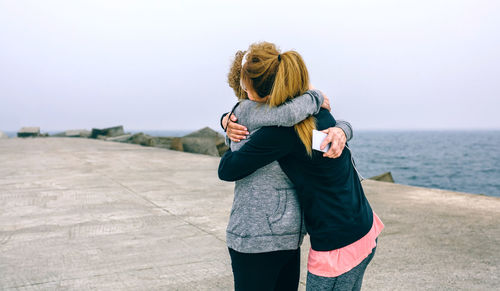 Full length of woman standing by sea against clear sky