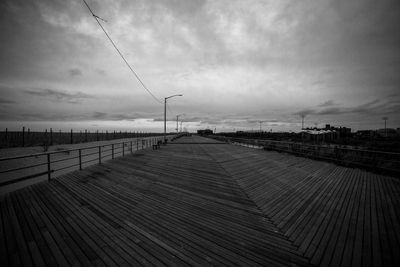 Footbridge against sky during sunset