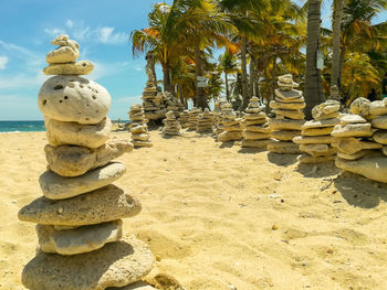 Stack of stones on beach against sky