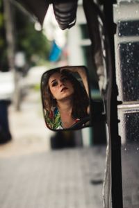 Reflection of woman seen in side-view mirror