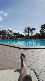 Low section of person standing on swimming pool