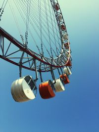 Low angle view of ferris wheel against clear blue sky