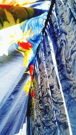 Close-up of multi colored paper hanging on clothesline