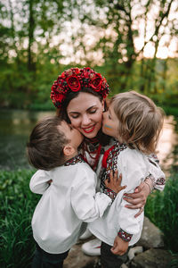 Boys kissing mother at park