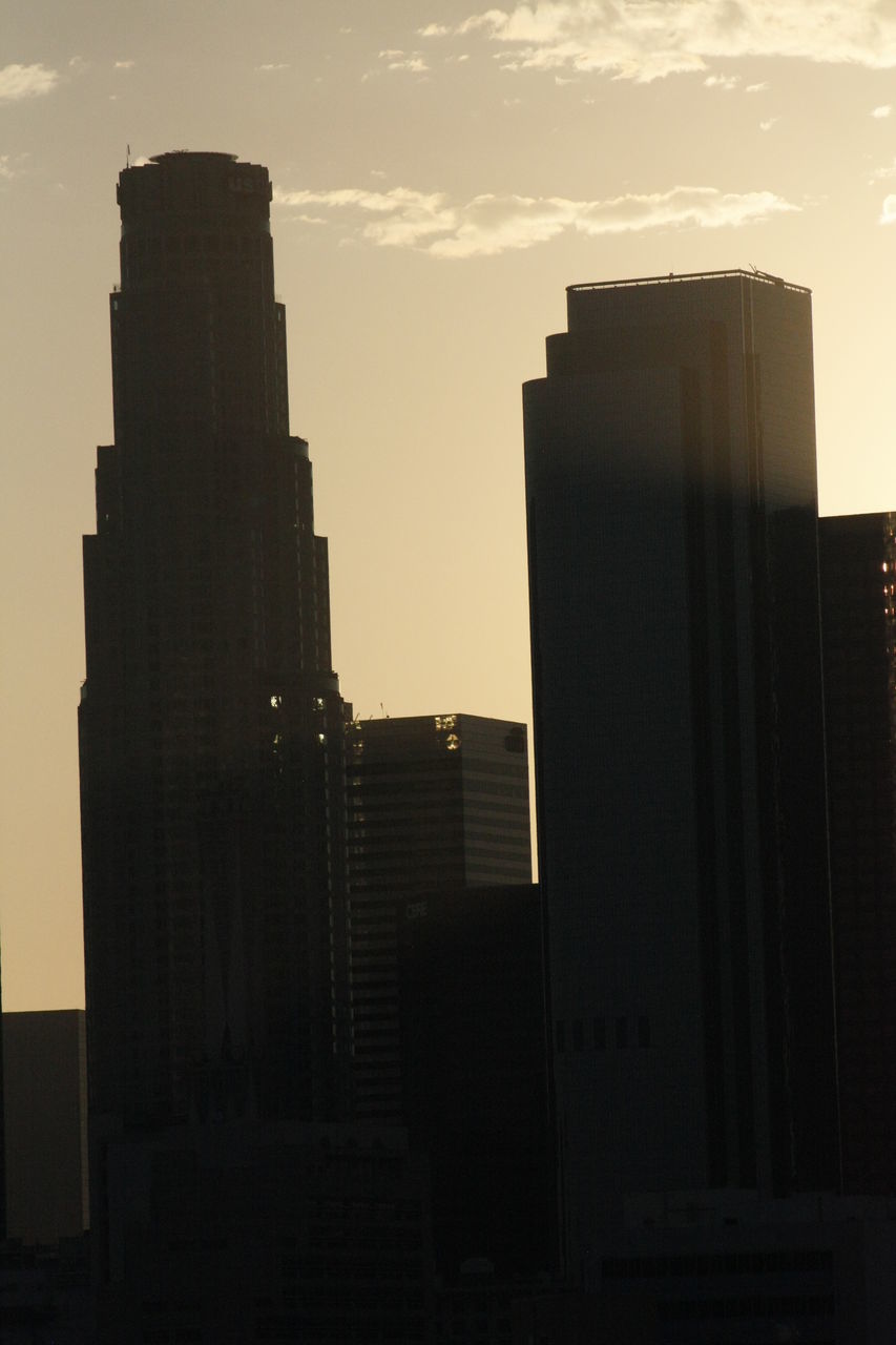 SILHOUETTE OF SKYSCRAPERS AGAINST SKY DURING SUNSET