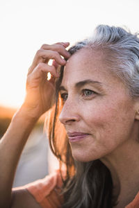 Portrait of gray haired woman at the beach for sunset