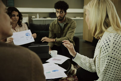 Group of business people analyzing charts during meeting in lobby