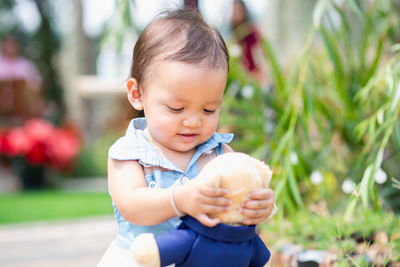 Close-up of cute baby boy holding plant