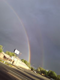 Scenic view of rainbow over buildings in city against sky