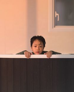 Portrait of boy against wooden wall