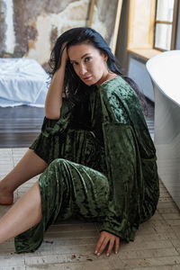 Young woman sitting on bed at home