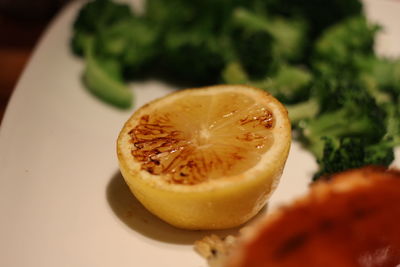 Close-up of halved lemon with food on plate