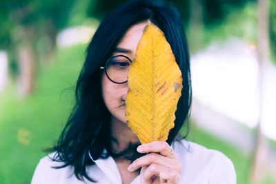 Woman holding yellow leaf