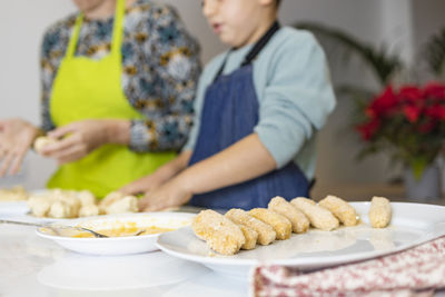 Mother and son making croquettes in the kitchen