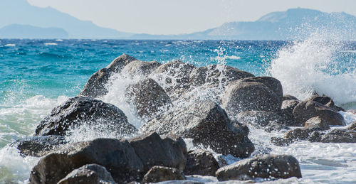 Waves at storm in mediterranean sea beating on breakwater on kos greece