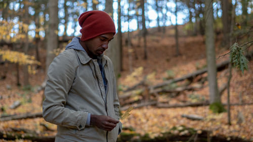 Man wearing hat standing in forest during autumn