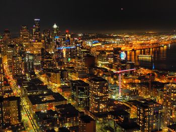 Illuminated cityscape against sky at night