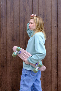 Young woman standing against wall