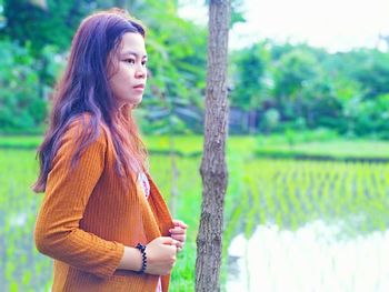 Side view of young woman looking away outdoors