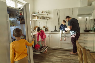 Man with children in kitchen at home