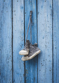 Shoes hanging on old wooden wall