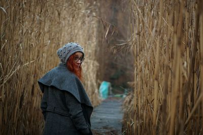 Woman standing by plants on field