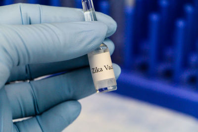 Cropped image of biologist holding zika vaccine at laboratory