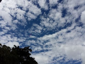 Low angle view of tree against cloudy sky