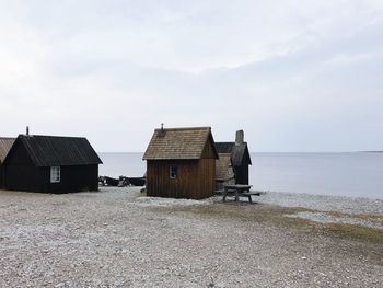 Huts on beach against clear sky