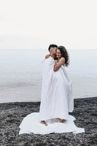 Couple on beach against sea against sky