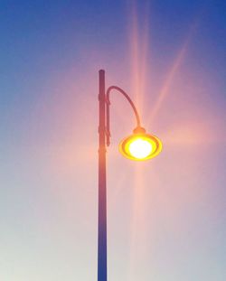 Low angle view of illuminated street light against sky