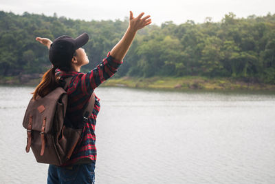 Full length of boy standing in water against sky