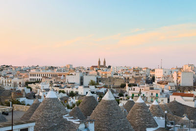 Aerial view of buildings in city against sky during sunset