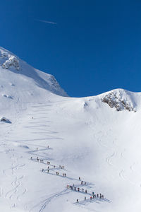 Scenic view of snowcapped mountains against clear blue sky