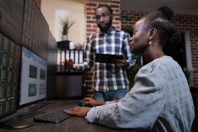 Business colleagues analyzing graph on computer