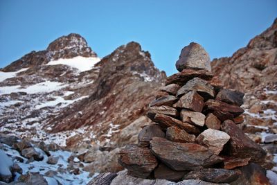 Stacked rocks against mountain during winter
