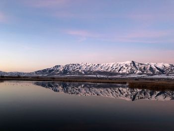 Scenic view of lake and snowcapped mountains against sky