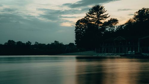 Scenic view of swimming pool by lake against sky during sunset