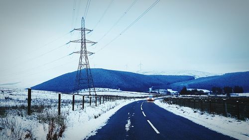 Electricity pylon on snow covered field