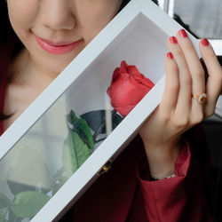 Close-up of woman holding red rose