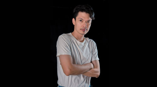 Portrait of a young man against black background