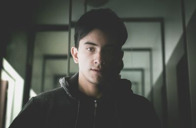 Portrait of young man standing at home