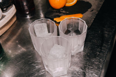 Close-up of ice cubes in drinking glasses on table
