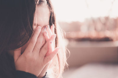 Close-up portrait of girl with hand in water