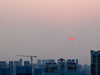 Buildings in city against sky at dusk